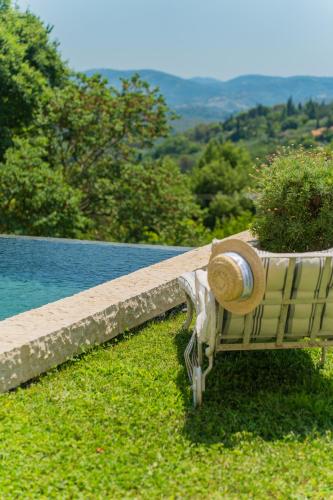 a bench with a plant on it next to a pool at Domaine de la Cascade Parfumée in Grasse