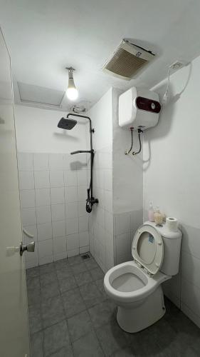 a bathroom with a toilet with a light on the ceiling at instaspace in Bandung