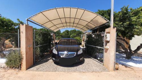 a car is parked in a garage with a gate at Monika's house in Chios