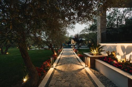 a walkway in a park with flowers and trees at Giardino Lux Apartments in Ulcinj