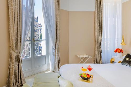 a bedroom with a bed and a window with fruit on a tray at Boscolo Lyon Hotel & Spa in Lyon