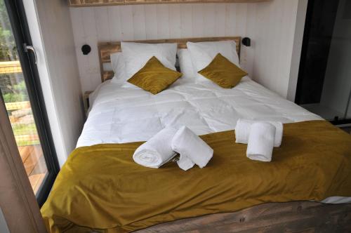 a white bed with two towels on it at Lodges Arverne in Vic-le-Comte