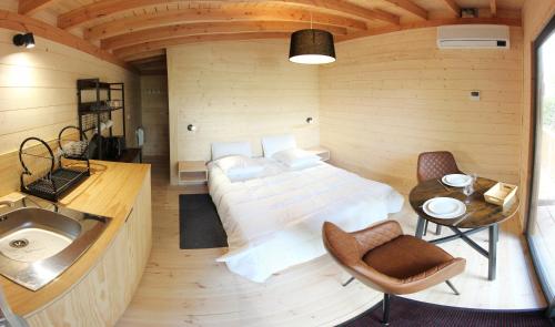 a bedroom with a bed and a sink in a room at Lodges Arverne in Vic-le-Comte