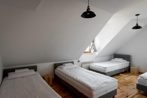 a bedroom with two beds and a window at Osada Dębno 