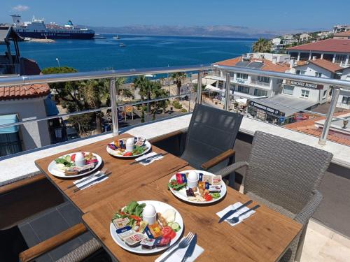 a table with plates of food on top of a balcony at Grand Faik Hotel in Cesme