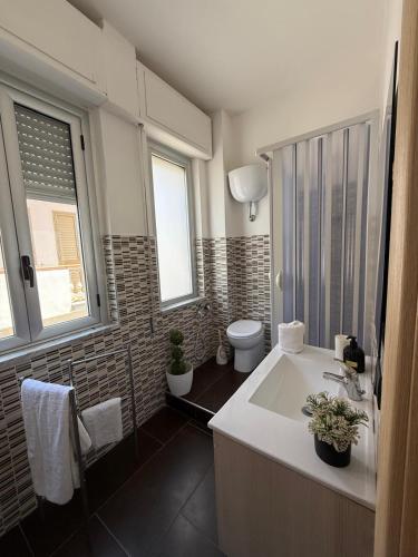 a bathroom with a tub and a toilet and a sink at Crisvan Home in Capo Rizzuto