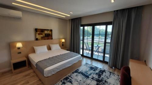 a bedroom with a bed and a large window at Maison 7 New Cairo in Cairo