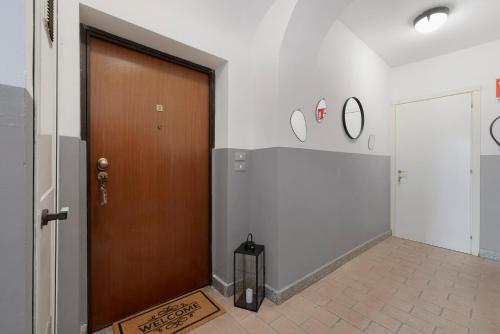 a wooden door in a hallway with a tile floor at Il Cappellaio Matto in Alessandria