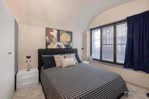 a bedroom with a bed and a large window at Il Cappellaio Matto in Alessandria