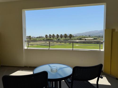 a room with a table and chairs and a large window at Kos Palace in Tigaki