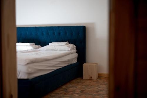 a blue bed with white sheets and pillows at Osada Dębno 