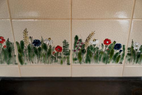 a row of flowers on a wall in a bathroom at Osada Dębno 