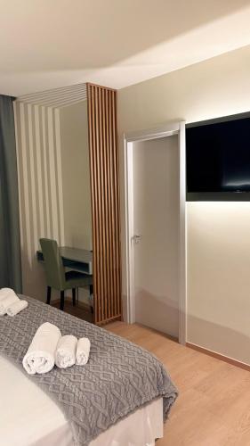 a bedroom with a bed with a flat screen tv at Hotel Milazzo Smart in Milazzo