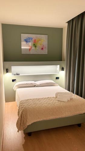 a bedroom with a bed with a green wall at Hotel Milazzo Smart in Milazzo