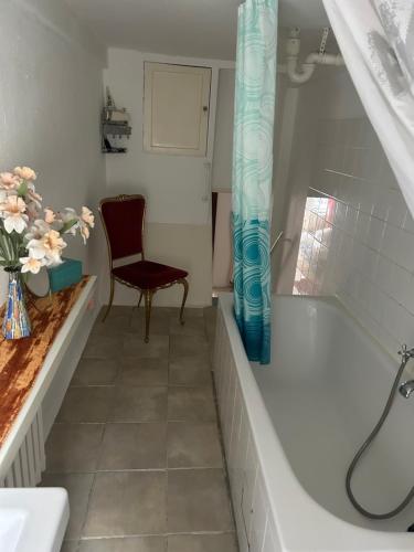 een badkamer met een bad en een stoel bij Kant in Berlijn