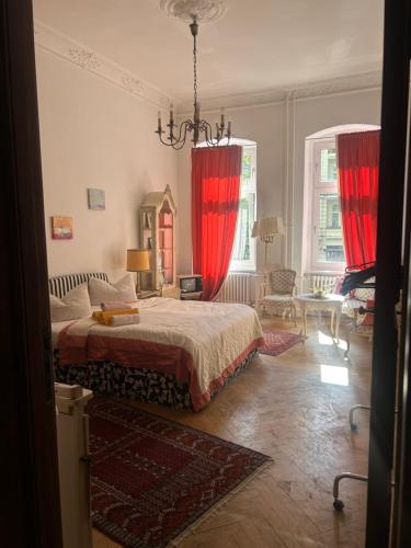 een slaapkamer met een groot bed met rode gordijnen bij Kant in Berlijn