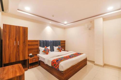 a bedroom with a large bed and a wooden cabinet at RROOMS Rachna Inn in Lucknow