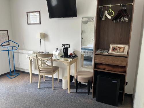a room with a desk and a table with a mirror at Logis Hotel-Restaurant "Auberge Le Petit pont" in Tennie