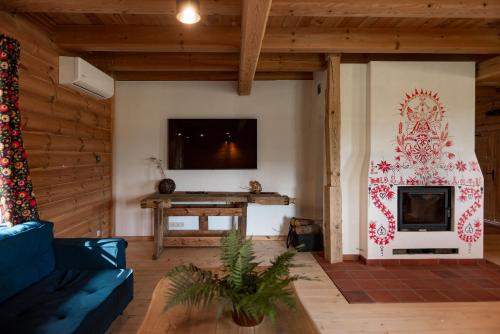 a living room with a fireplace and a tv at Osada Dębno 