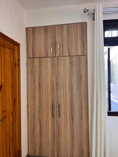 a large wooden cabinet in a room with a window at Joubarbe Residence in Moka