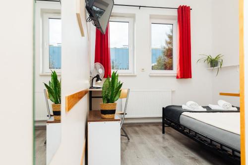 a bedroom with a bed and two windows at Arcus Premium Hostel in Warsaw