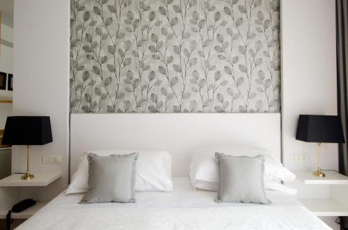 a bedroom with a white bed with two pillows at Hotel Concord - Nel cuore di Riccione in Riccione