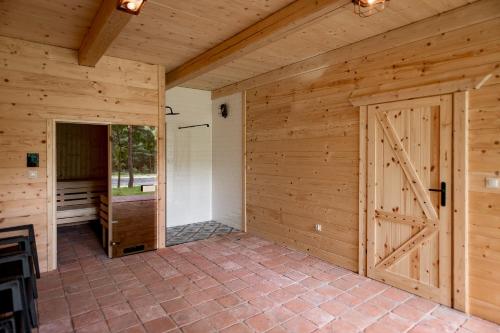 a large room with wooden walls and a large door at Osada Dębno 