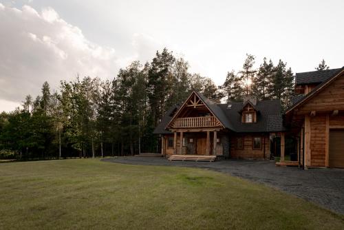 a house with a large yard in front of some trees at Osada Dębno 