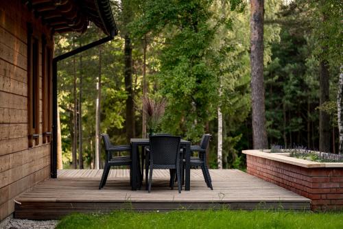 a table and chairs sitting on a wooden deck at Osada Dębno 