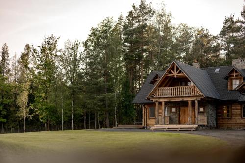 a log home with a black roof at Osada Dębno 