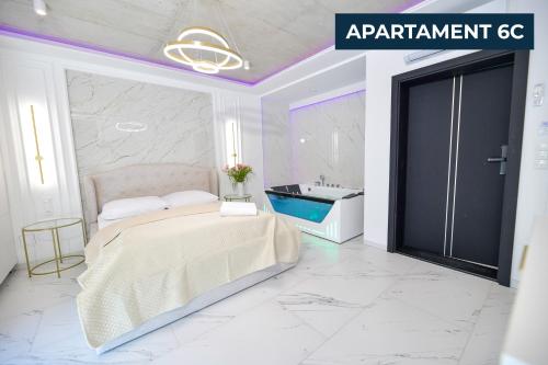 a bedroom with a bed and a bathroom with a tub at Słoneczne Wzgórze Zator in Zator