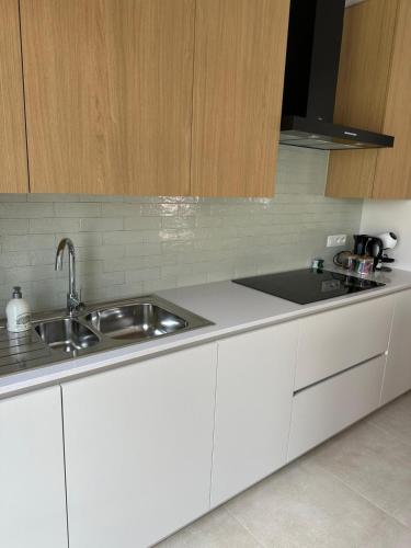 a kitchen with white cabinets and a sink at Sœur in Berlare