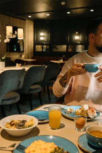 un hombre sentado en una mesa con un tazón de comida en Radisson Blu Hotel, Madrid Prado, en Madrid