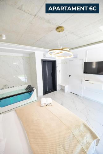 a white room with a bed and a chandelier at Słoneczne Wzgórze Zator in Zator