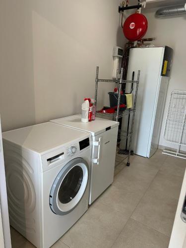 a washing machine in a room with a refrigerator at Sœur in Berlare