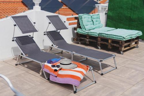 a pair of chairs and a table on a balcony at AL-Odeceixe Verde in Odeceixe