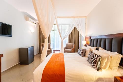 a hotel room with a large bed and a chair at Victoria Falls Rainbow Hotel in Victoria Falls