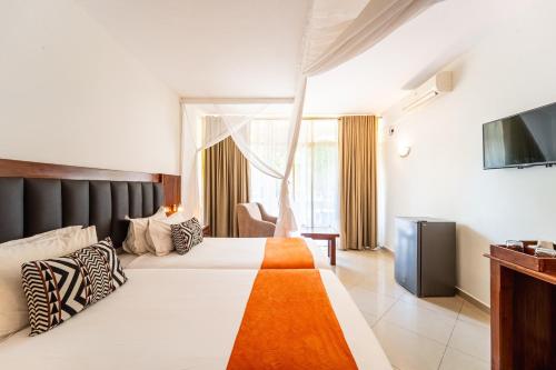 a hotel room with a bed and a television at Victoria Falls Rainbow Hotel in Victoria Falls
