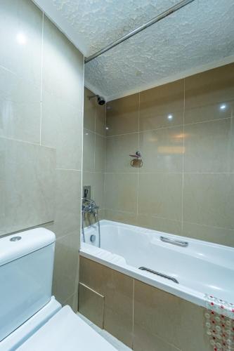 a bathroom with a bath tub and a toilet at Victoria Falls Rainbow Hotel in Victoria Falls