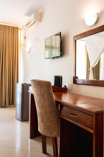 a desk with a chair and a mirror in a room at Victoria Falls Rainbow Hotel in Victoria Falls
