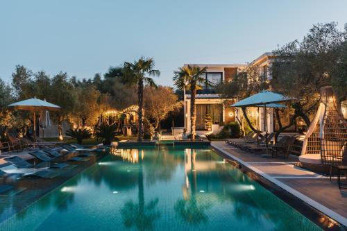 a swimming pool with lounge chairs and umbrellas at Giardino Lux Apartments in Ulcinj