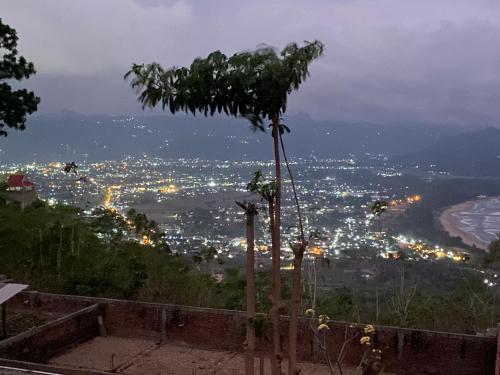 a view of a city at night with a tree at Enjoy Sunrise Pacitan Camping Ground in Tamperan
