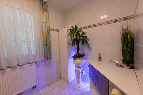 a bathroom with a plant in a vase at Ferienhaus Bergblick Redlham 
