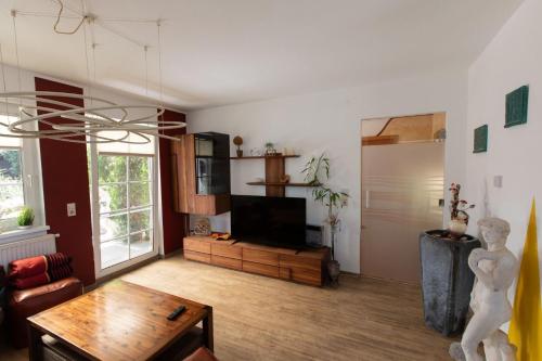 a living room with a tv and a table at Ferienhaus Bergblick Redlham 