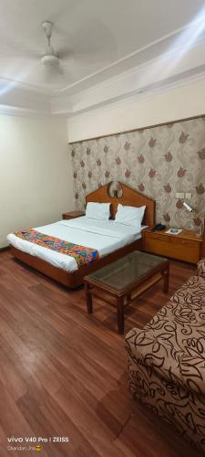 a bedroom with a bed and a coffee table at Kochar by guruji hospitality in New Delhi