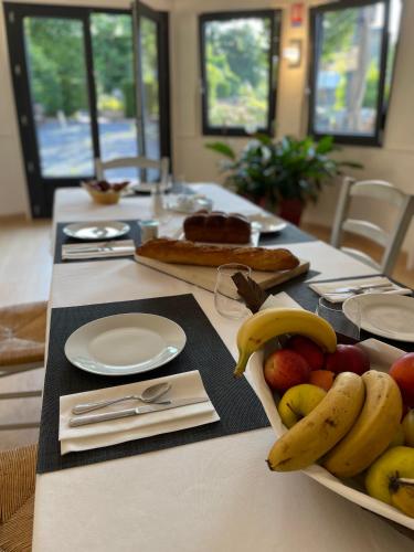 a table with bananas and apples and bread on it at Maison SOLAR in La Roquette