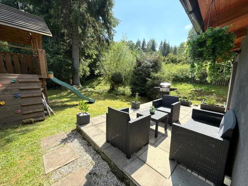 a backyard with a patio with chairs and a table at Horský dům pod přehradou u sjezdovky a potůčka v horách in Český Jiřetín