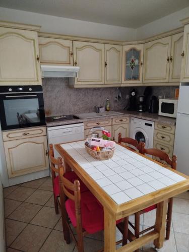 une cuisine avec une table et un panier dans l'établissement Le Relais de la Bulle Enchantée, à Hautvillers