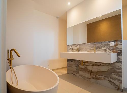 a bathroom with a tub and a sink at Villa Adeona in Zonza