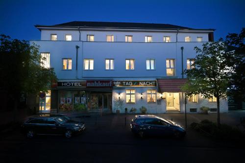 two cars parked in front of a hotel at night at Hotel Bürgerhof in Cologne